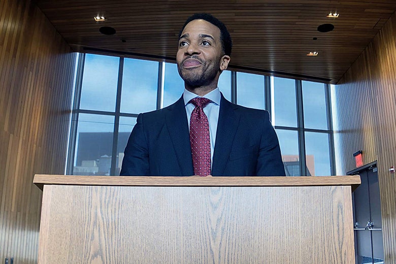 Andre Holland stands at a podium.